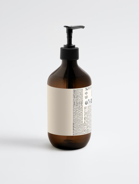 Brown bottle with pump and white label on a light gray background